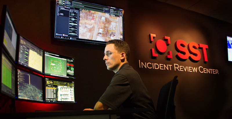 Employee in front of several monitoring screens at the company's Incident Review Center.