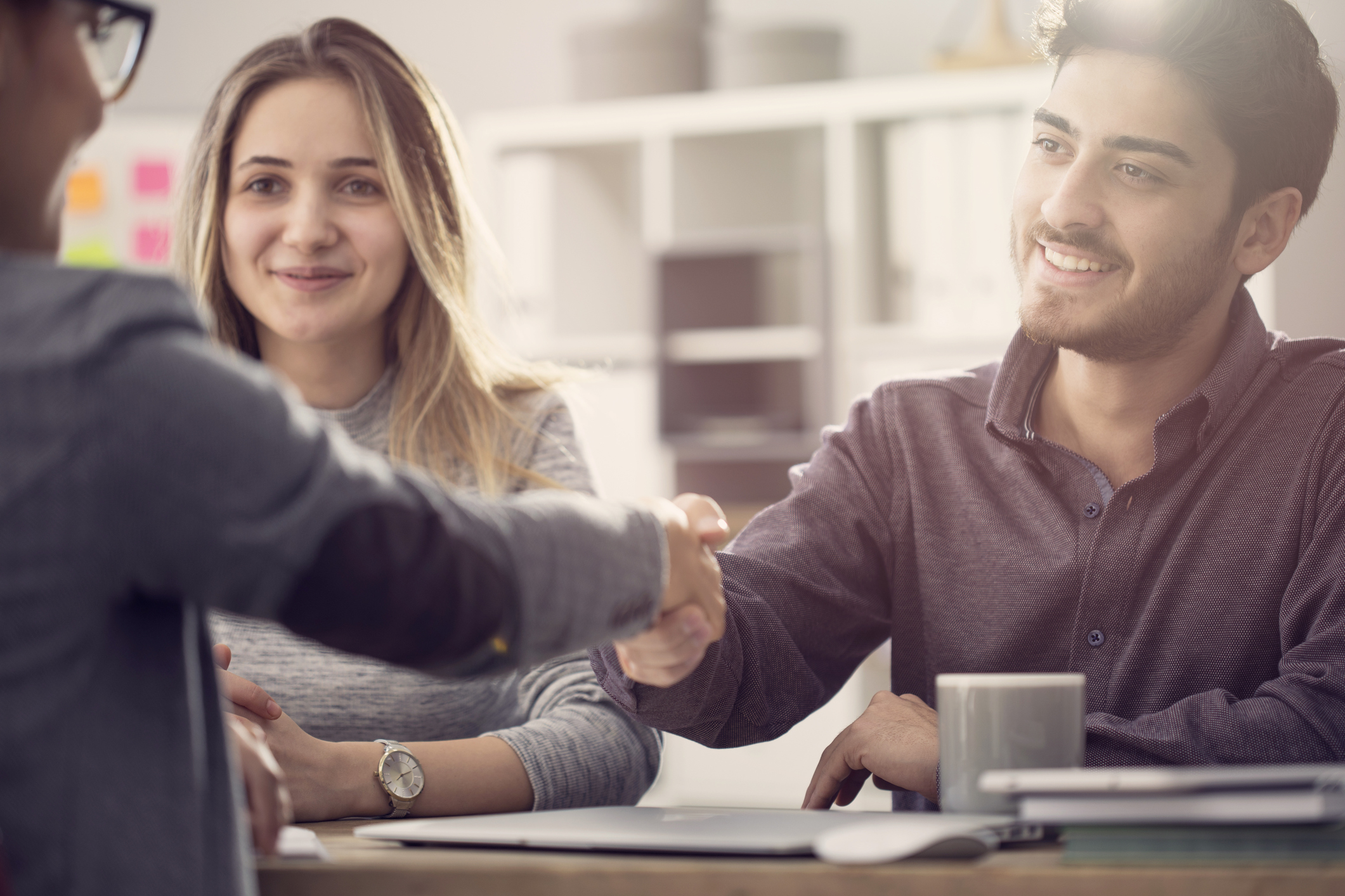 Young couple shaking hands with banker.