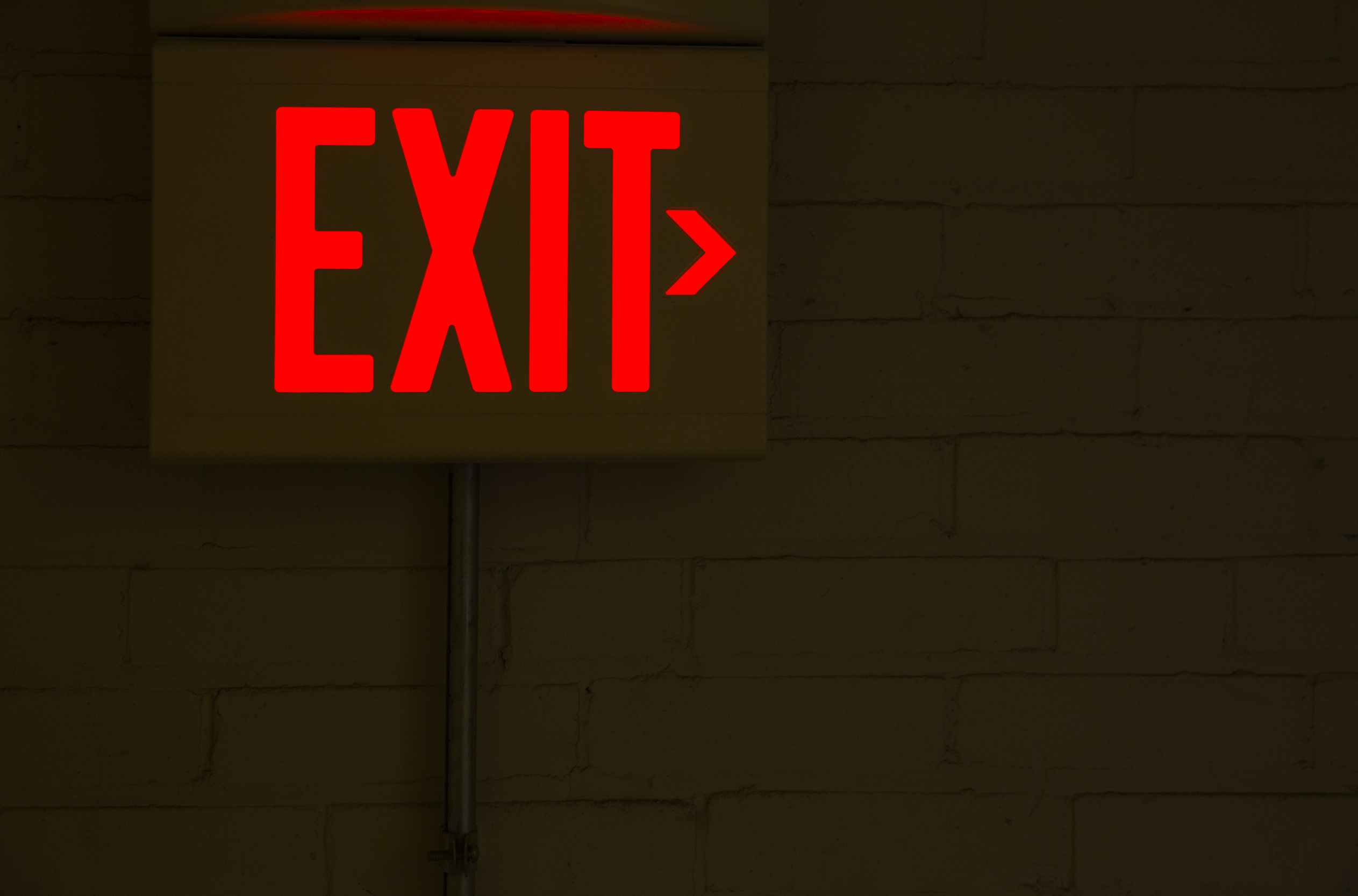Neon exit sign in a dark room.