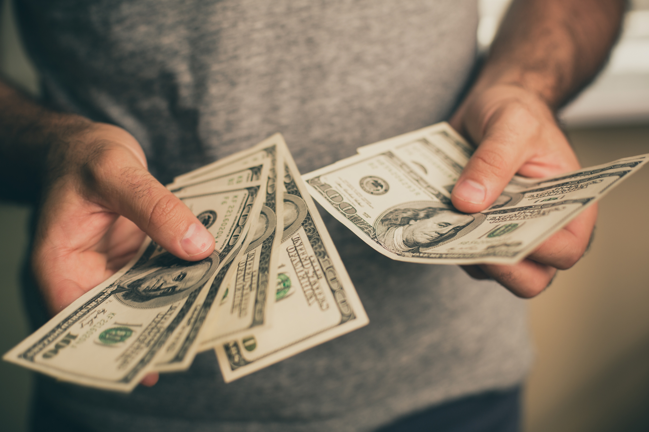Man holding hundred-dollar bills
