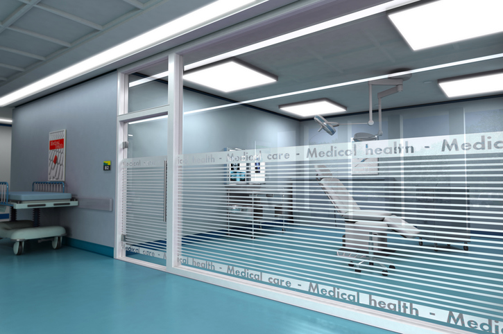 View of a medical office through a glass wall from what looks like a common area.