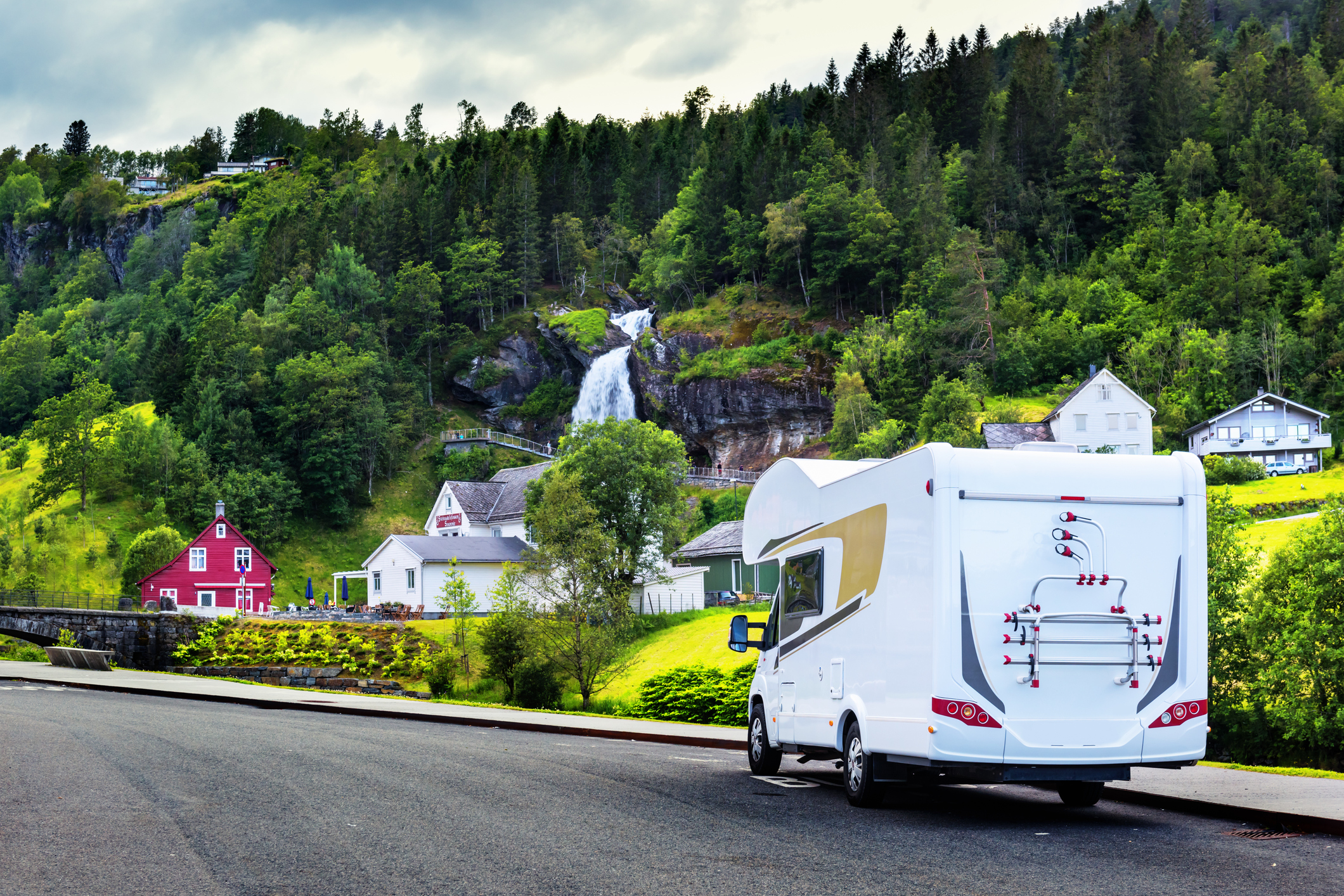 Camper parked near scenic waterfall.