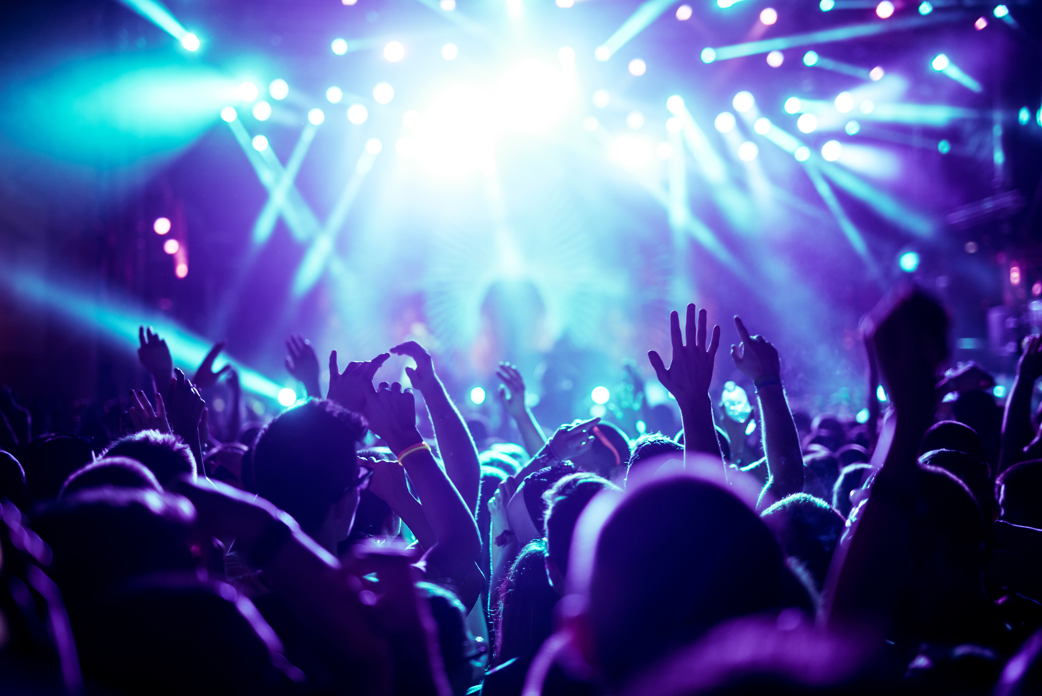 Hundreds of concert fans facing a stage