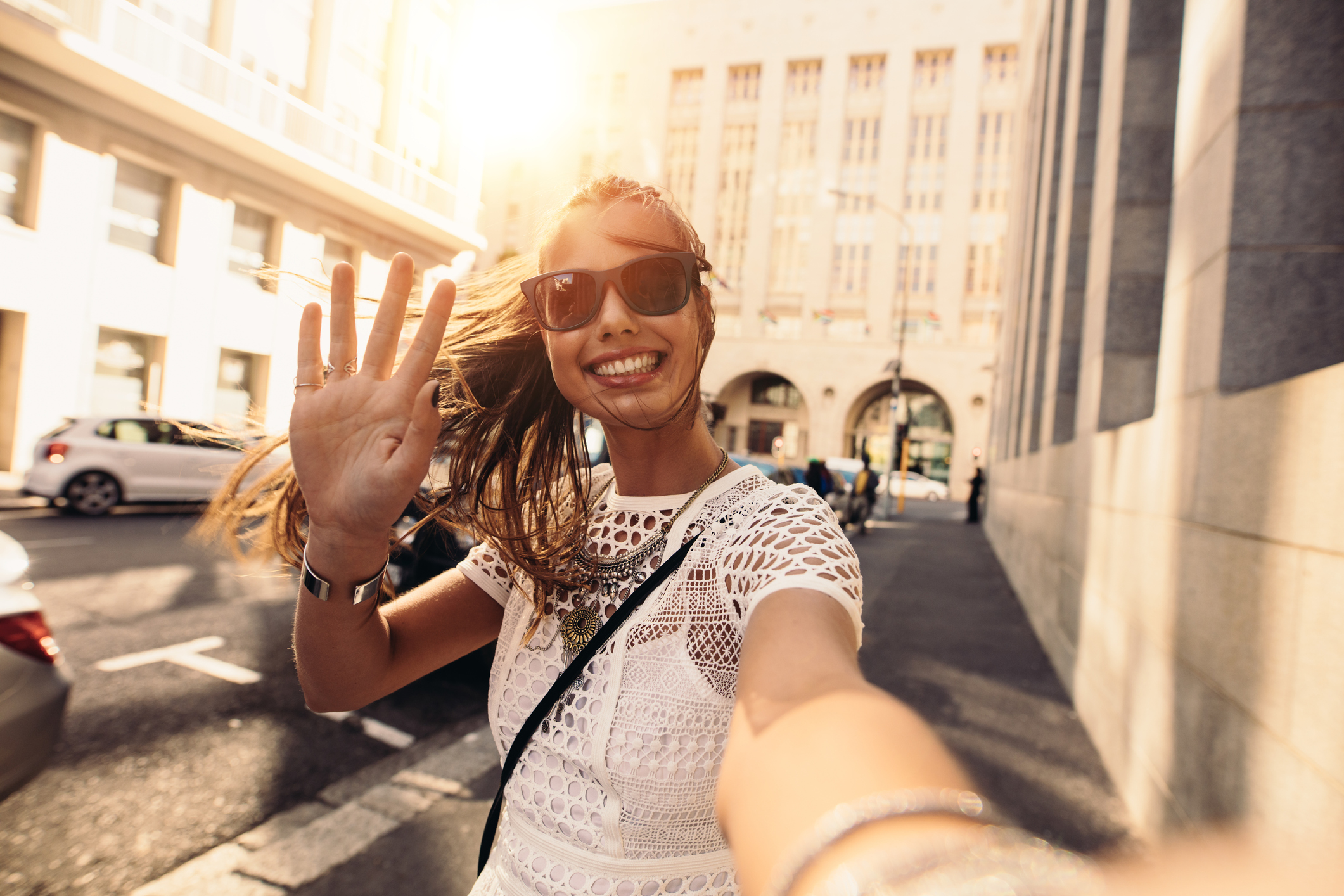 A young woman takes a selfie on a street.