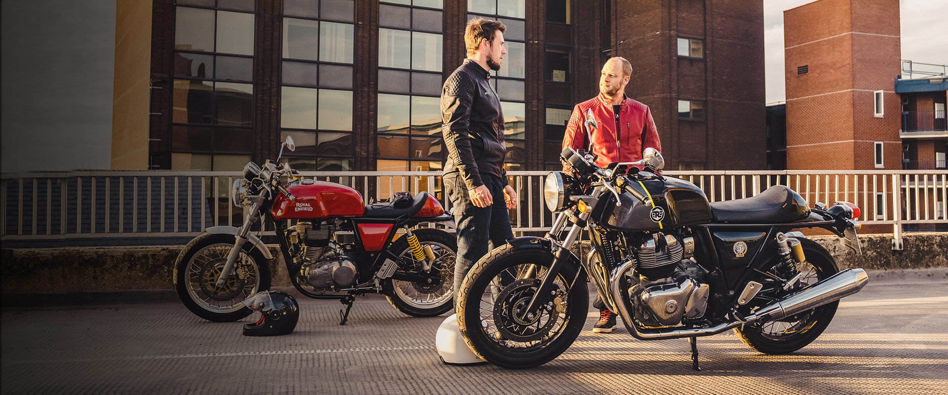 Two men standing by two motorcycles