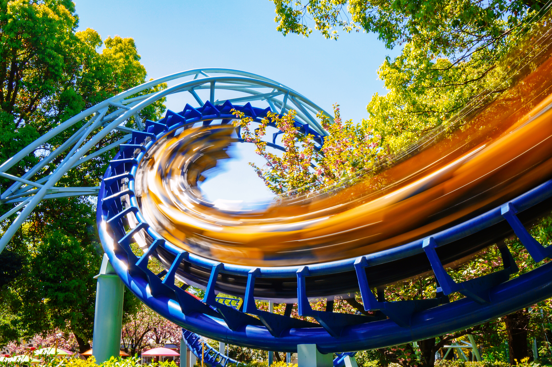 A yellow roller coaster speeds through a corkscrew loop