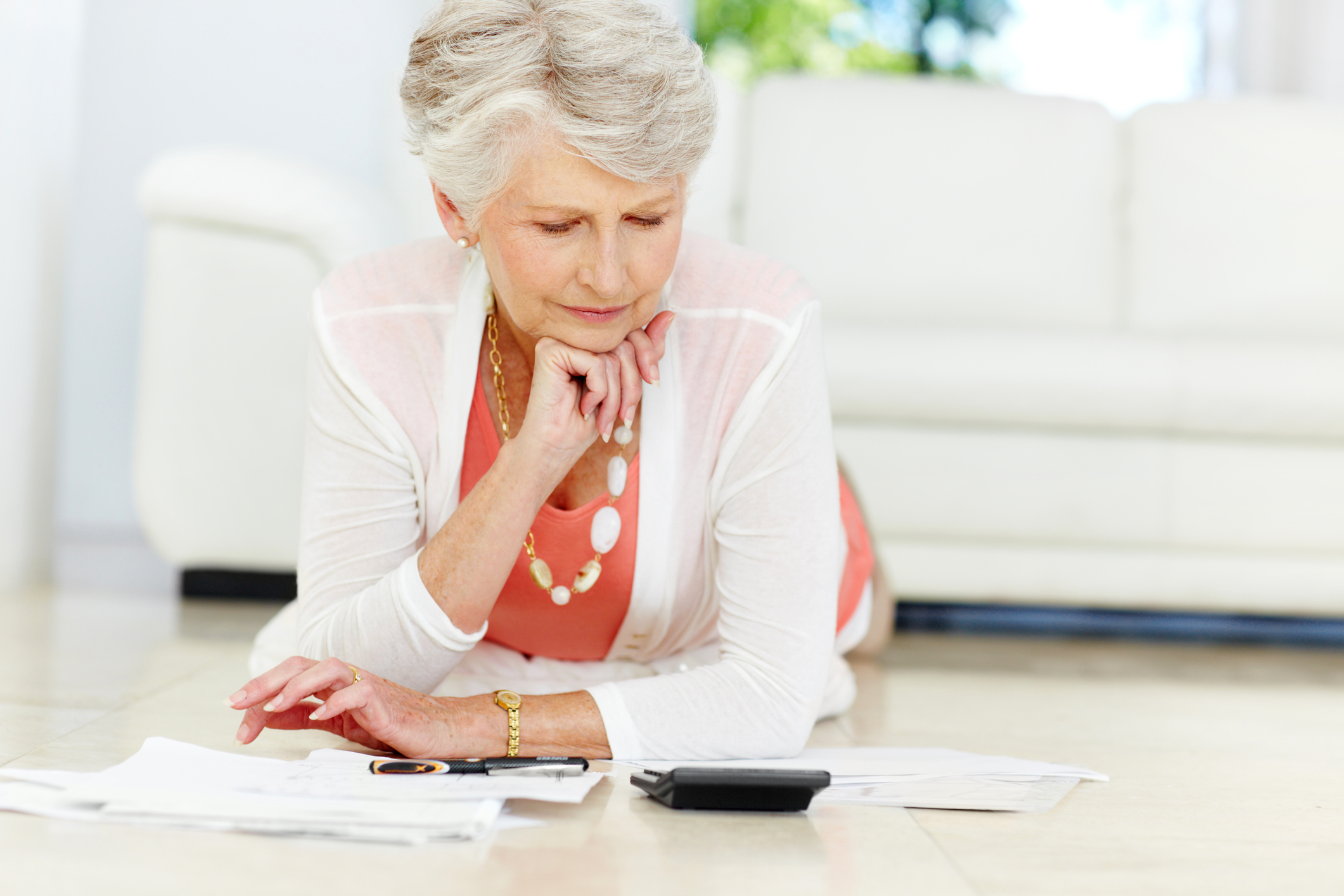 Senior woman looking at papers and calculator