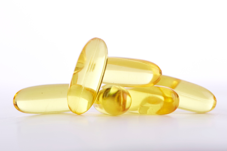 Seven light-gold-colored capsules on a flat surface.