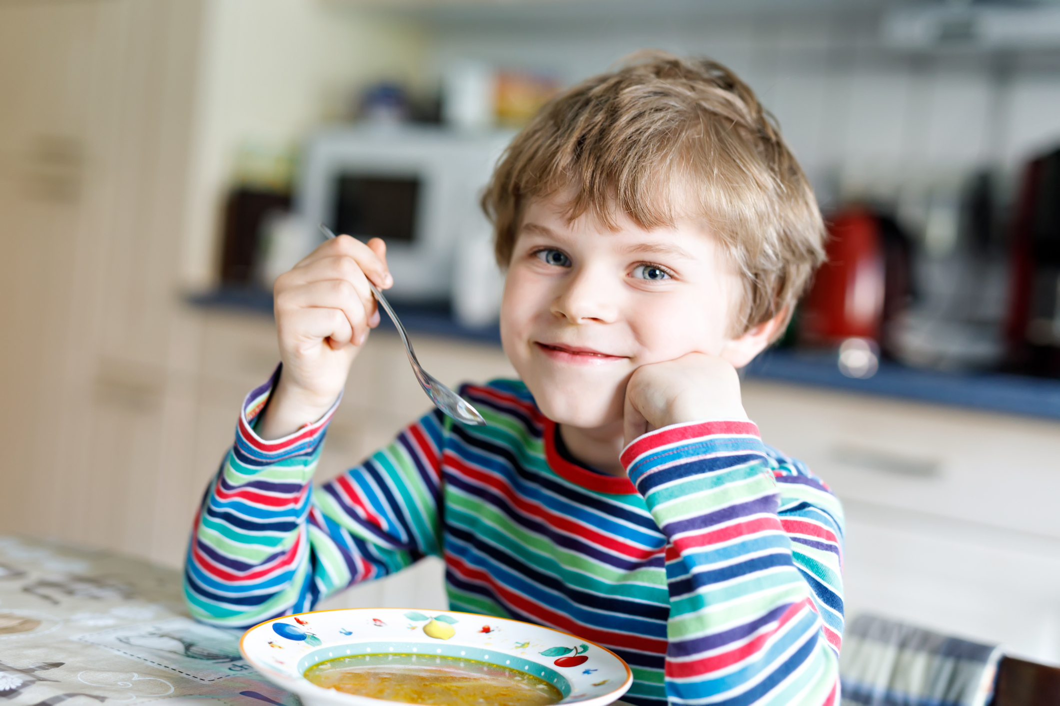 Boy eating bowl of soup