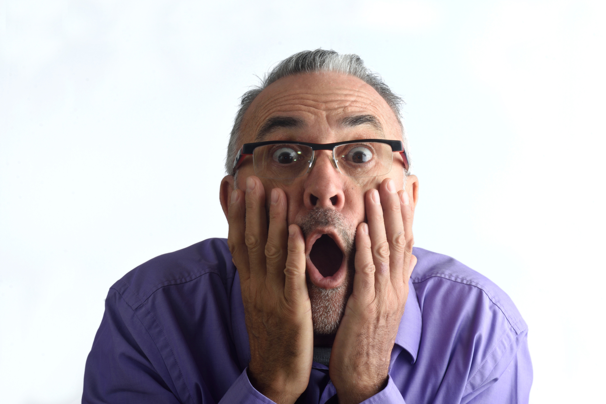 Very surprised middle-aged man with mouth open and hands on cheeks.