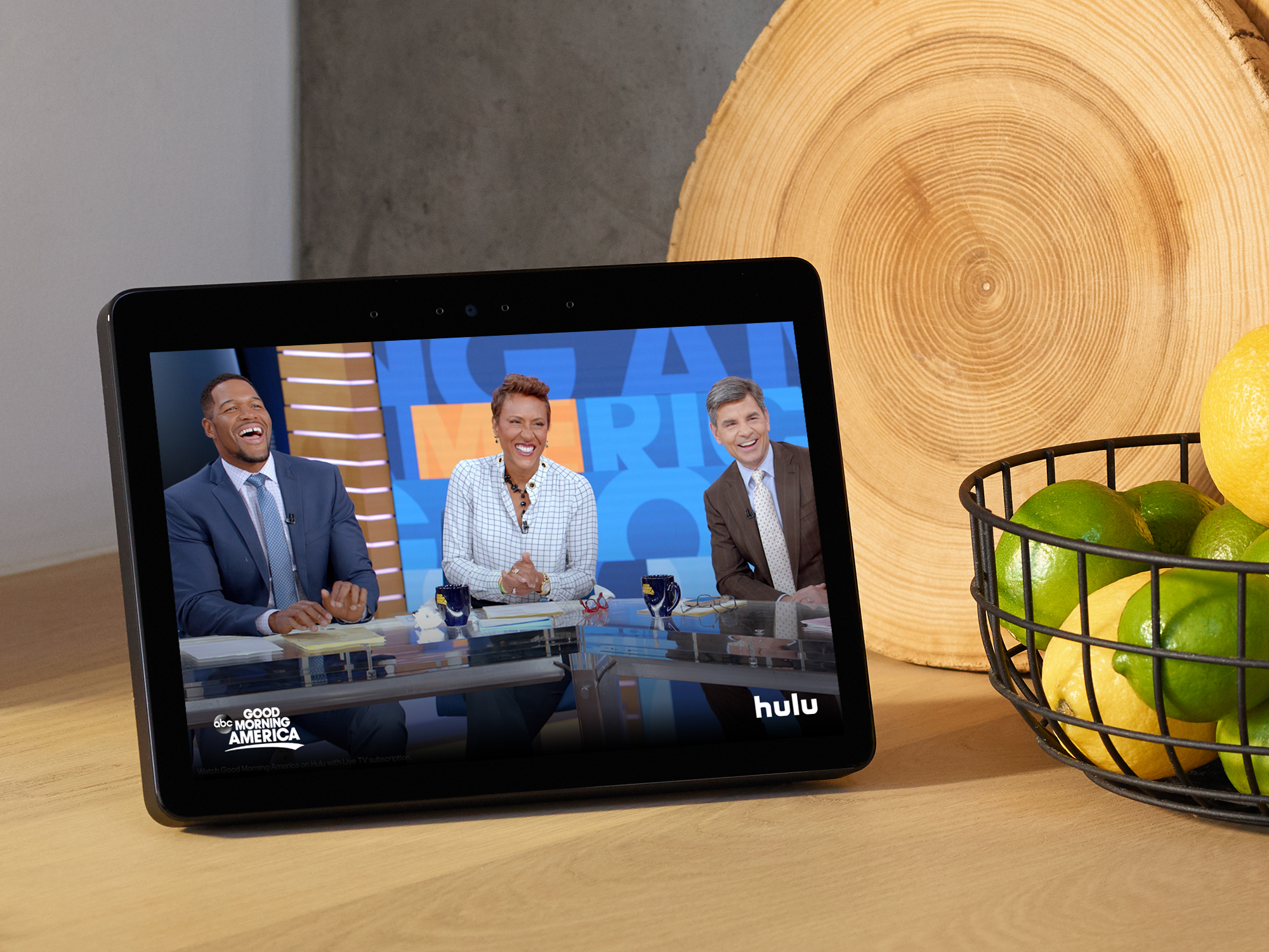 New Echo Show on a kitchen counter next to wire bowl holding lemons and limes