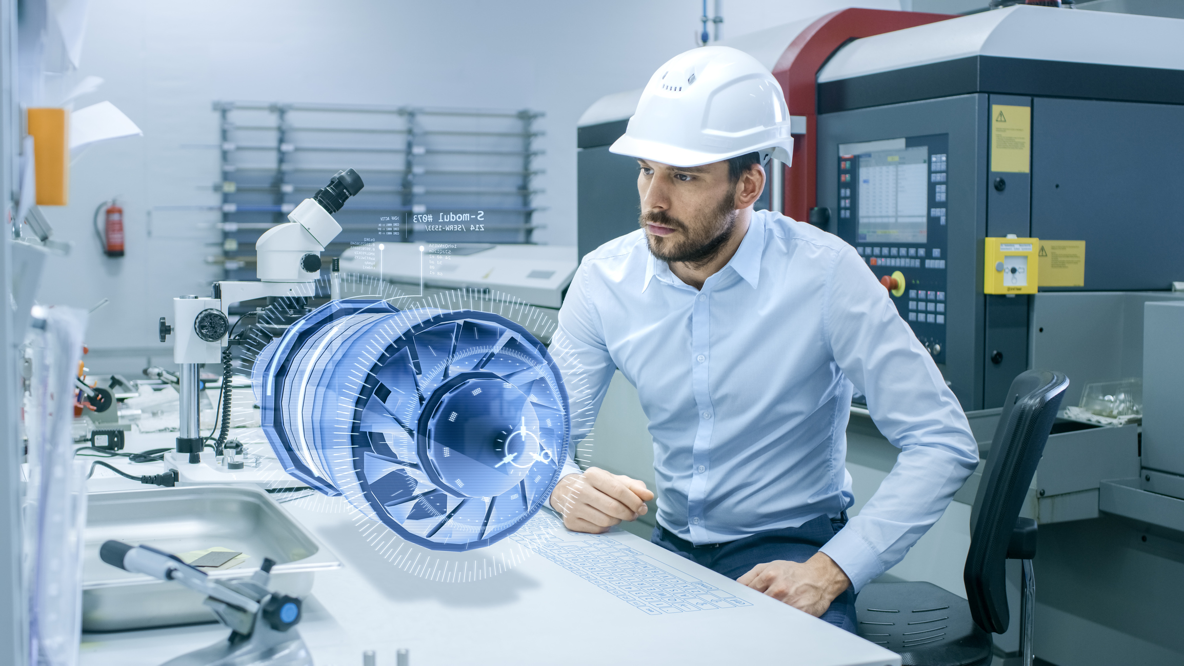 A man in a hard hat looks at a floating 3D object