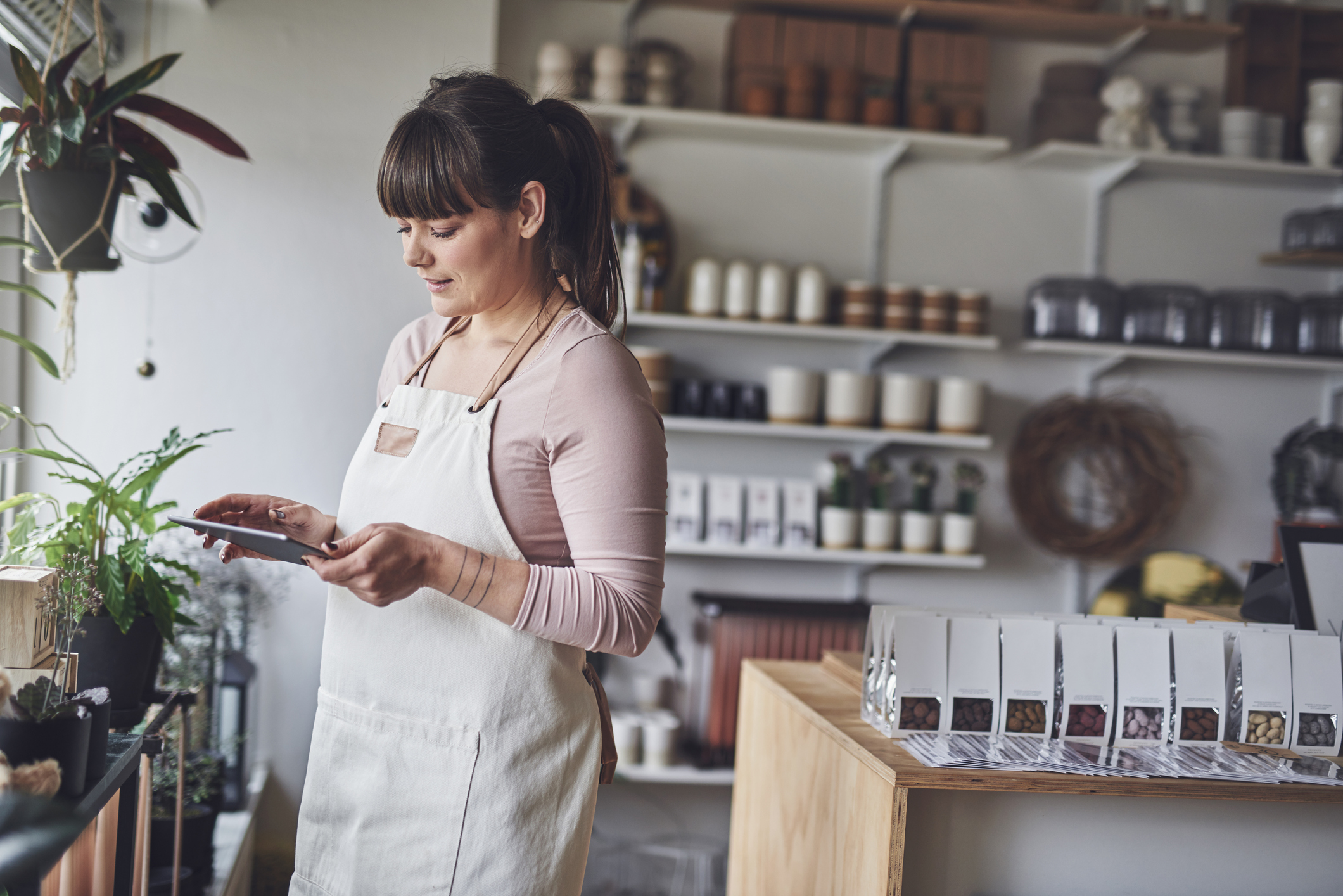 Shop owner smiling working on a tablet.