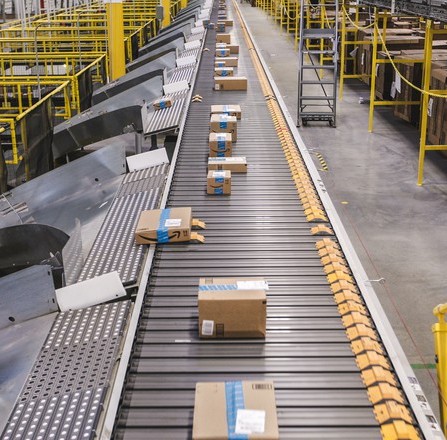 Packages moving on a conveyor belt in a fulfillment center.