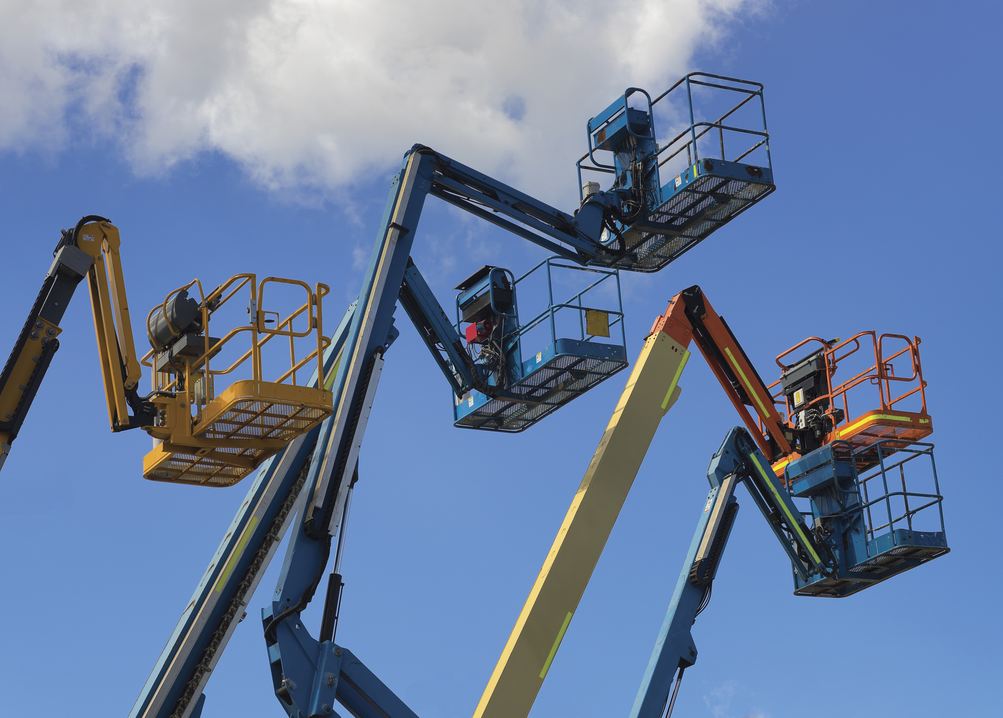 The platforms of a group of aerial work platforms, or "cherry pickers"