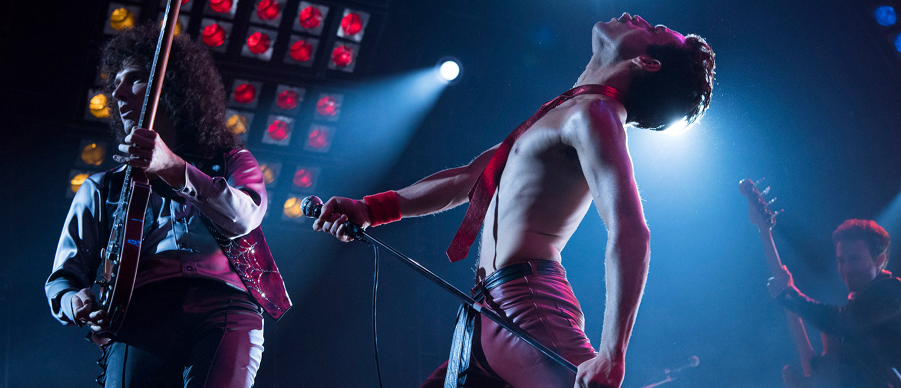 A scene from the movie Bohemian Rhapsody in which the band Queen is performing on stage.