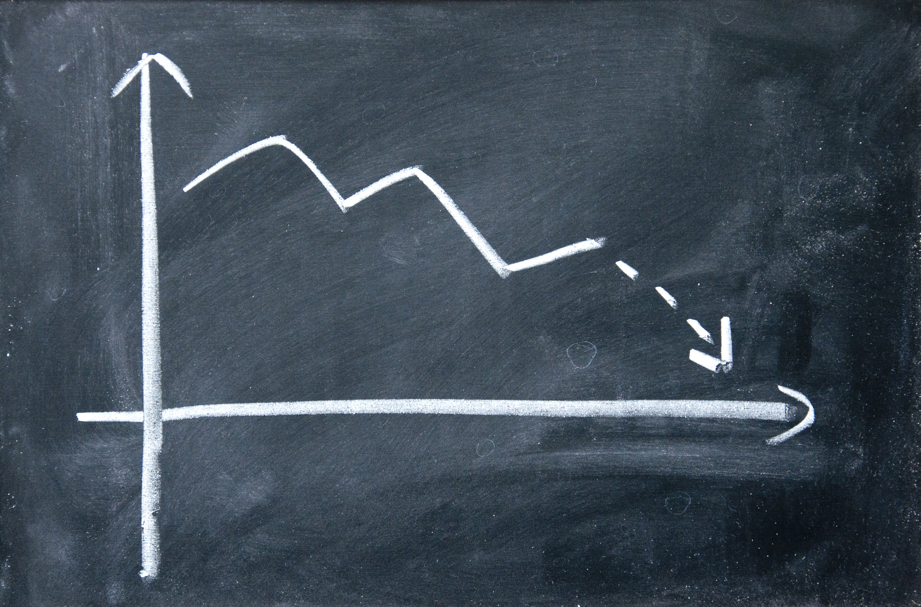 Chalkboard chart of a downward trending arrow.