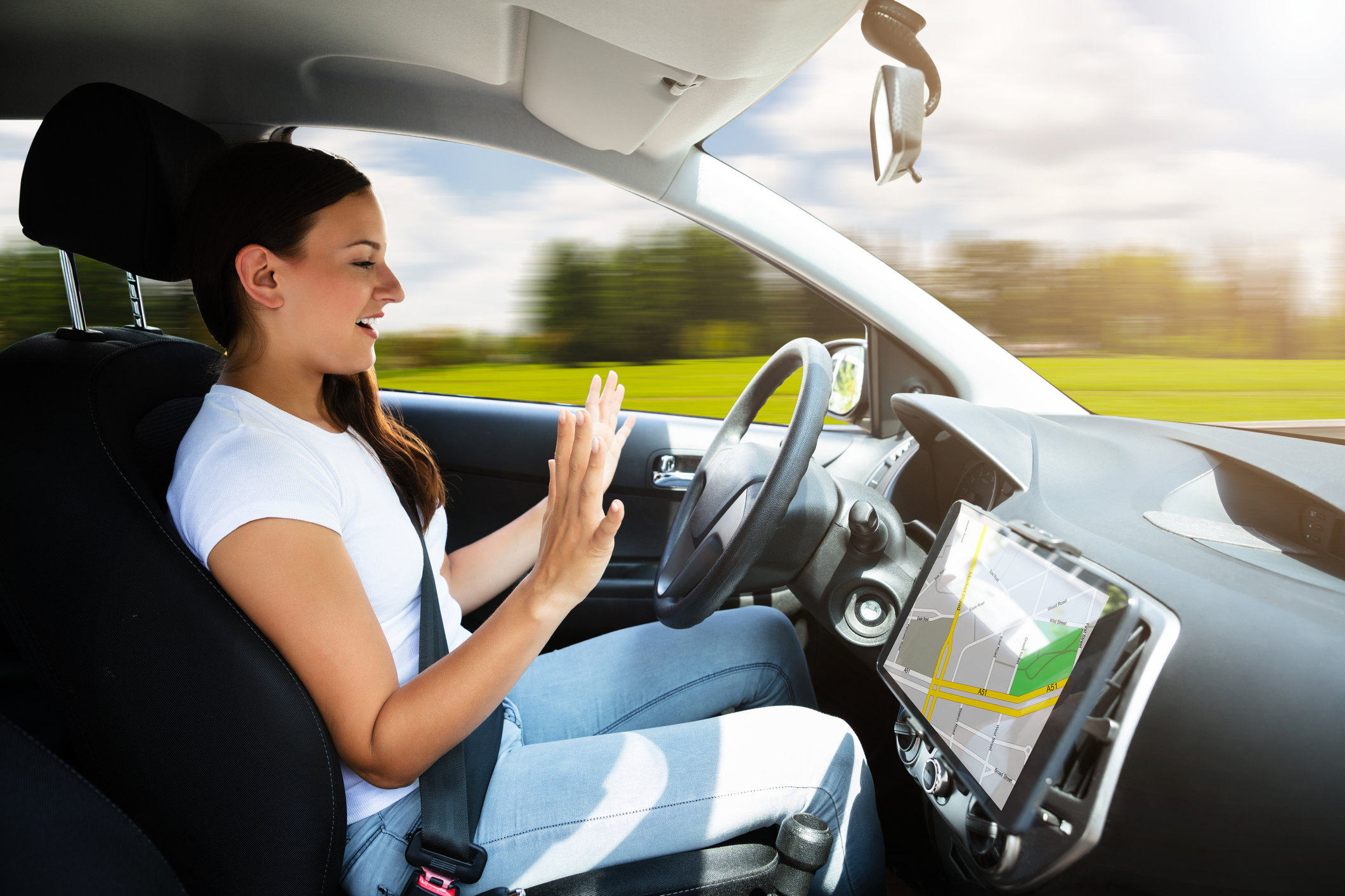 Woman sitting in car with her hands off of the steering wheel.