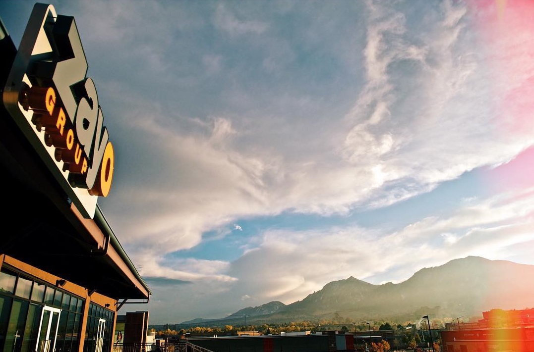 Storefront with Zayo Group signage with a mountain and sky view in the distance.