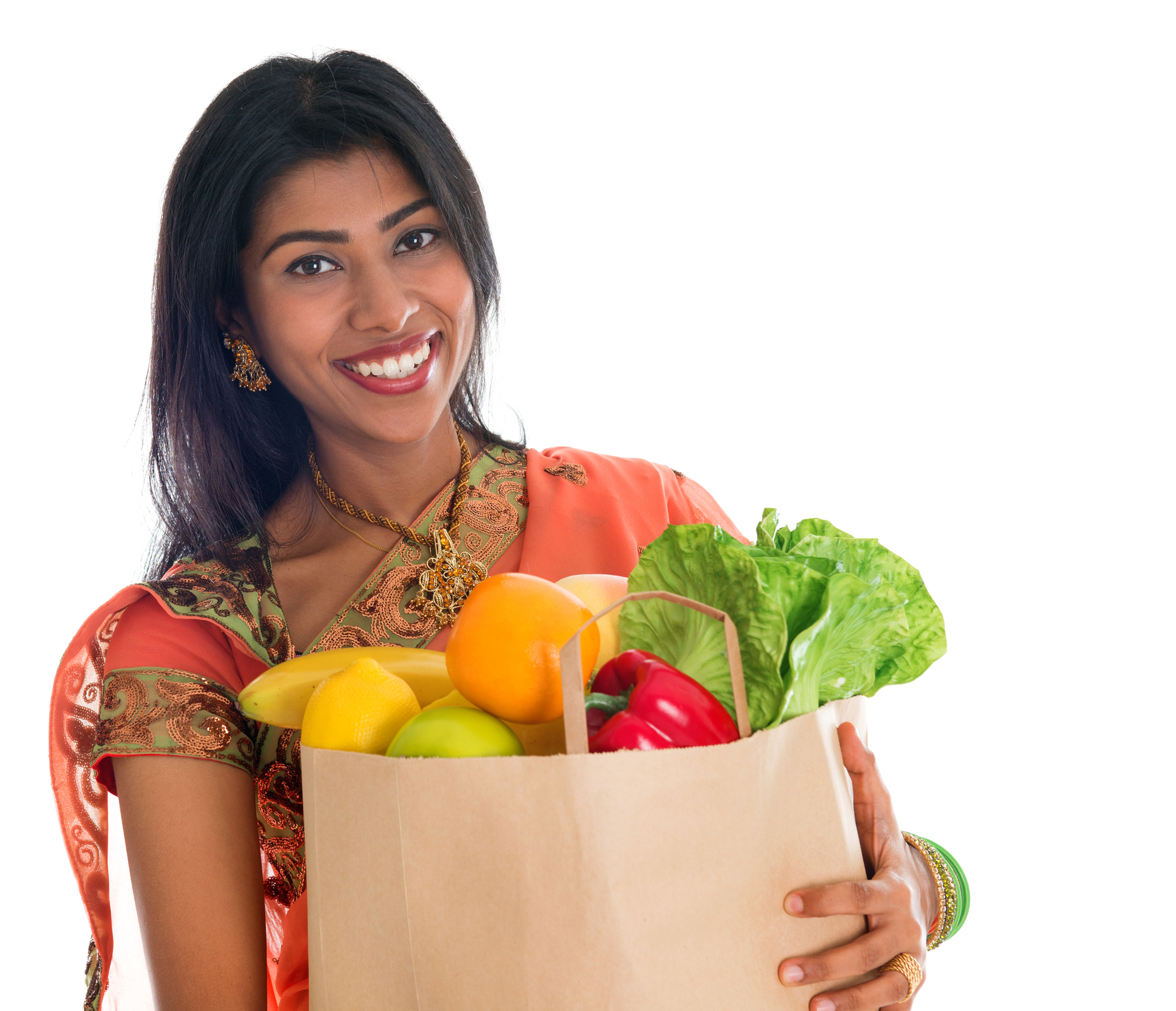Woman smiling carrying bag of groceries.