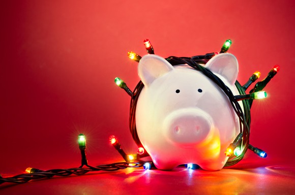 A piggy bank wrapped in Christmas lights.