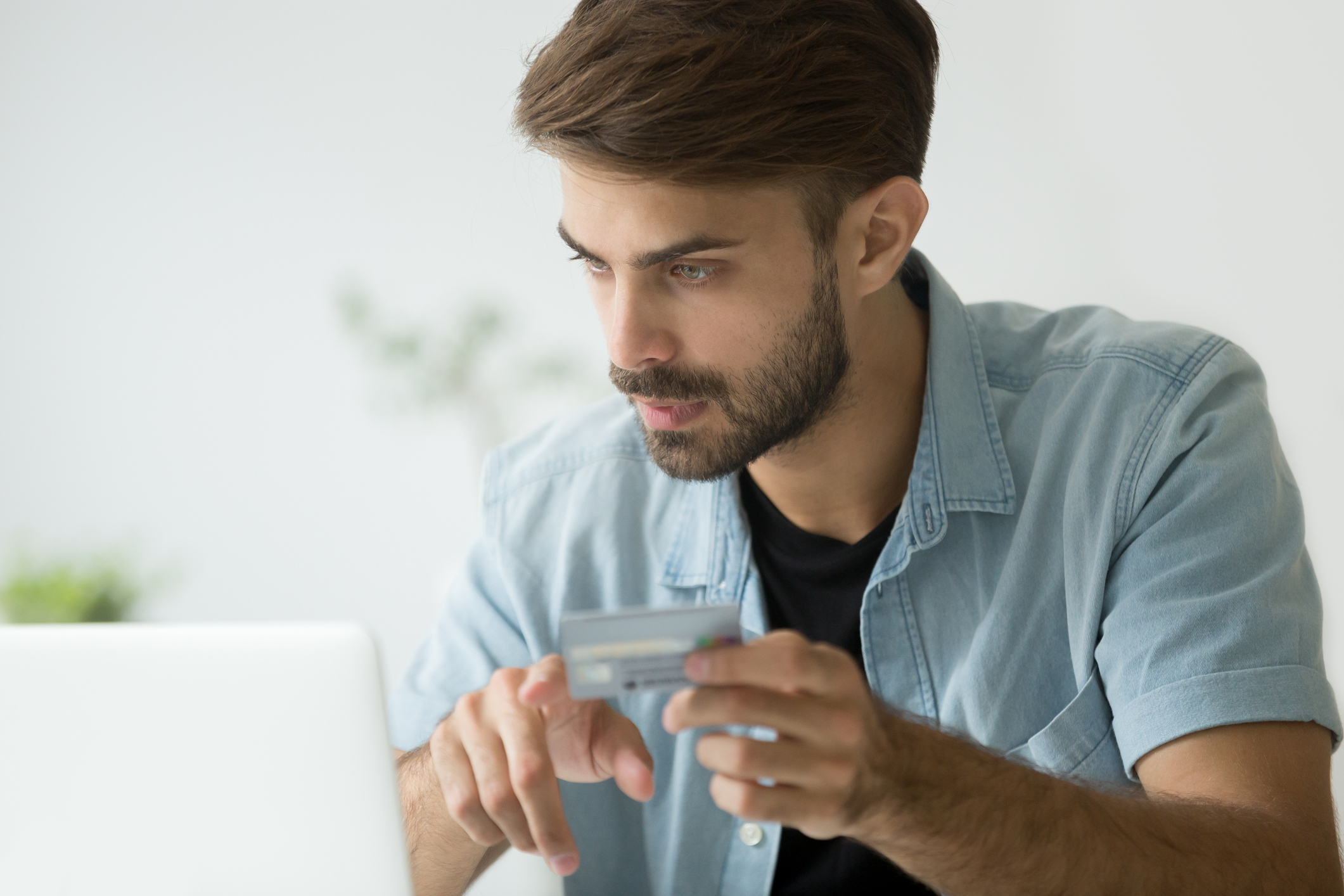 Young man at laptop with credit card
