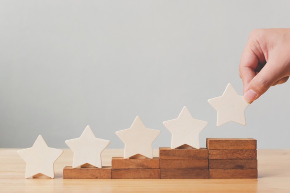 Five wooden stars on top of five ascending wooden stacks.