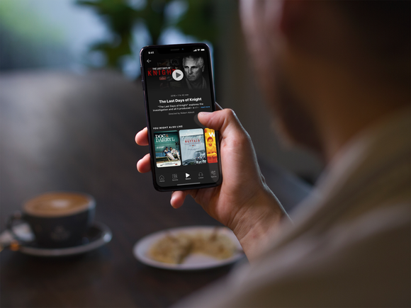 A man using the ESPN Plus app on his smartphone.
