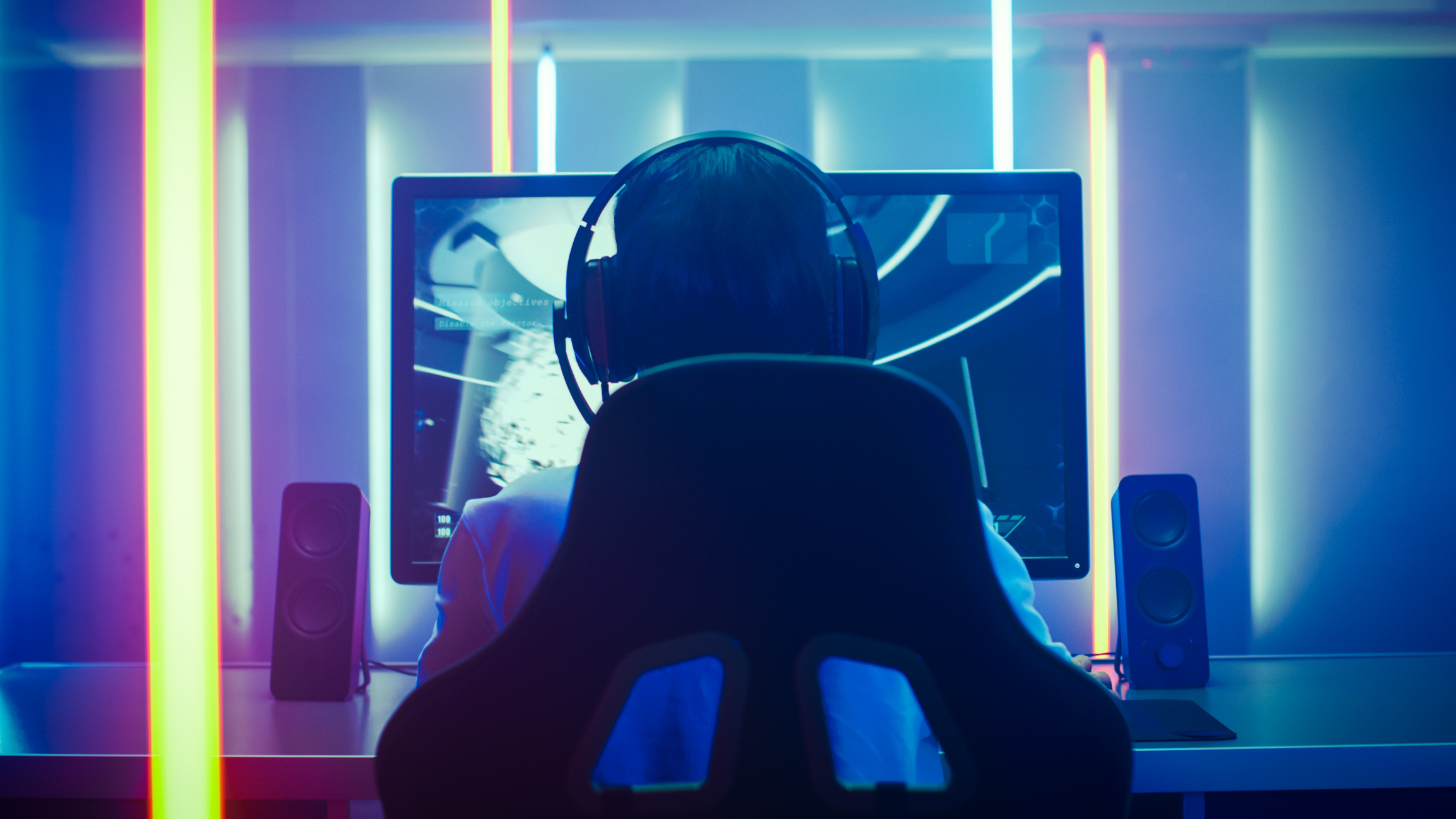 A person in a chair looking at a computer monitor.