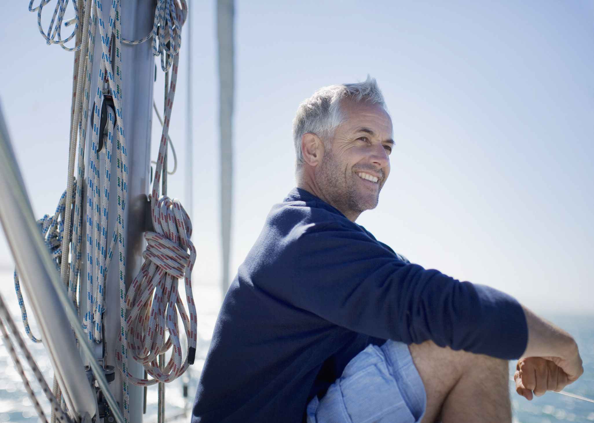 Older man on a boat, smiling.