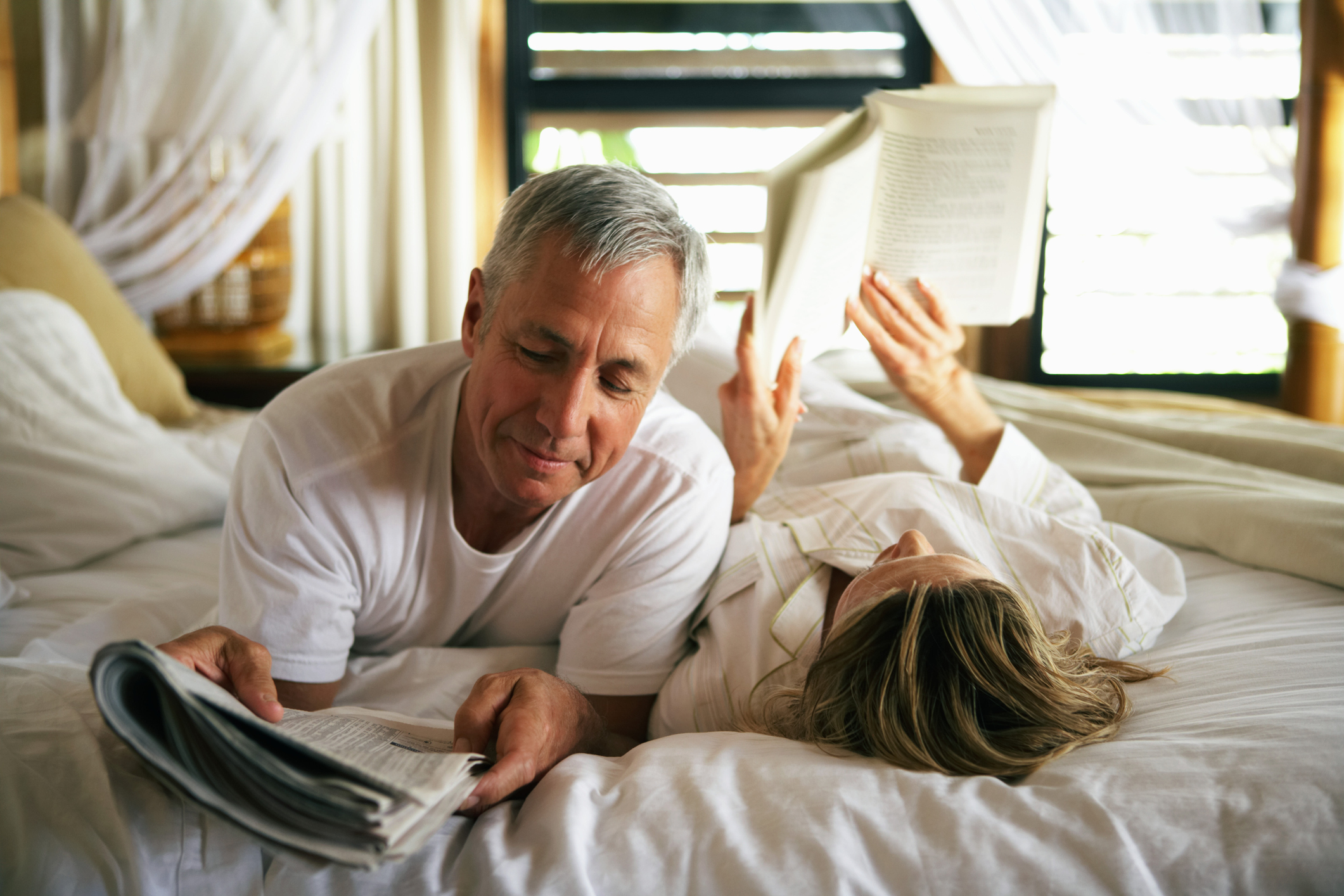 A senior couple reading in bed.
