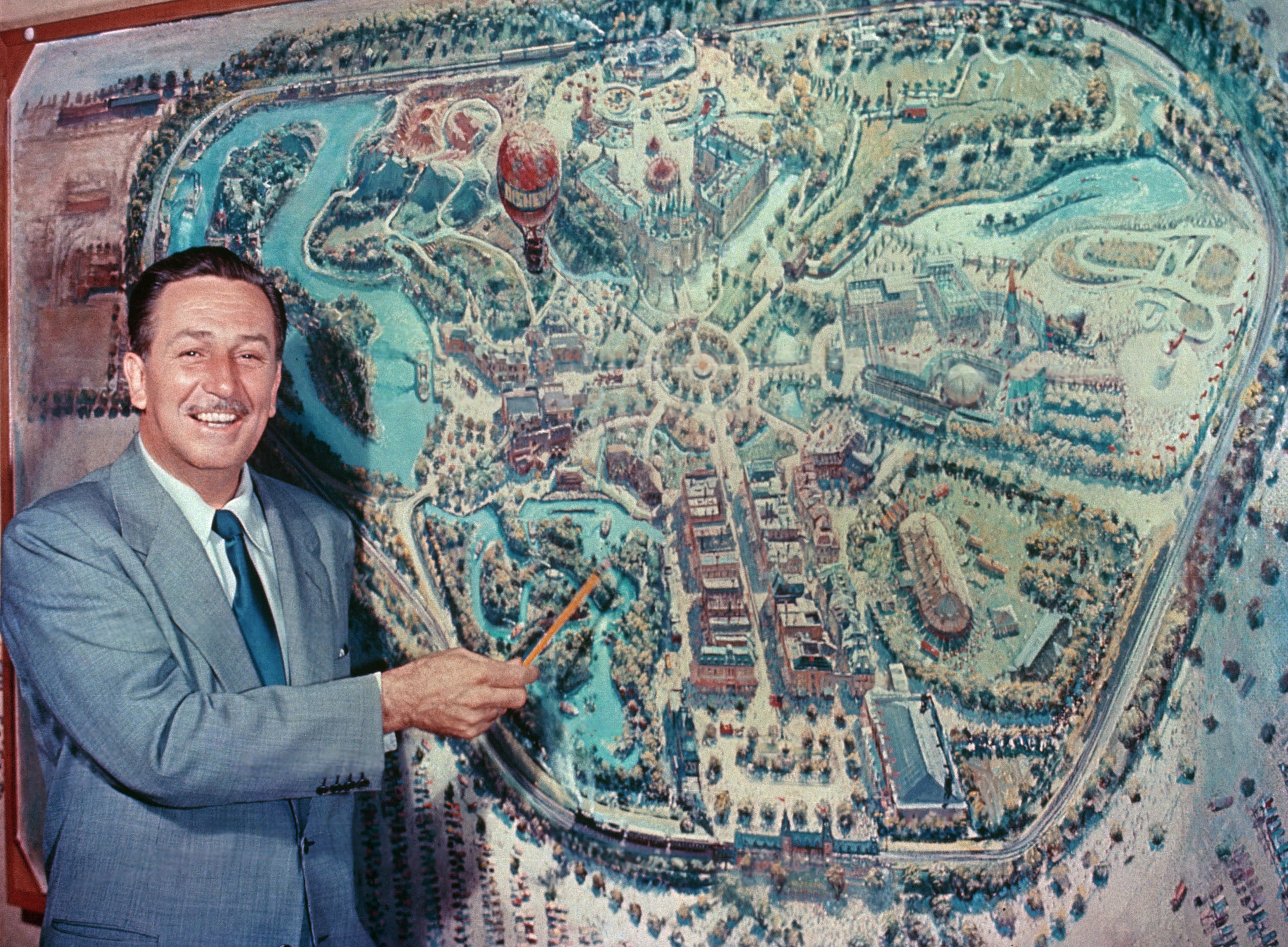 Walt Disney pointing to park plans.