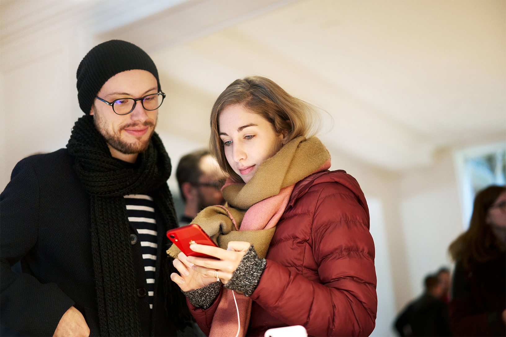 Customers using an iPhone XR in an Apple Store