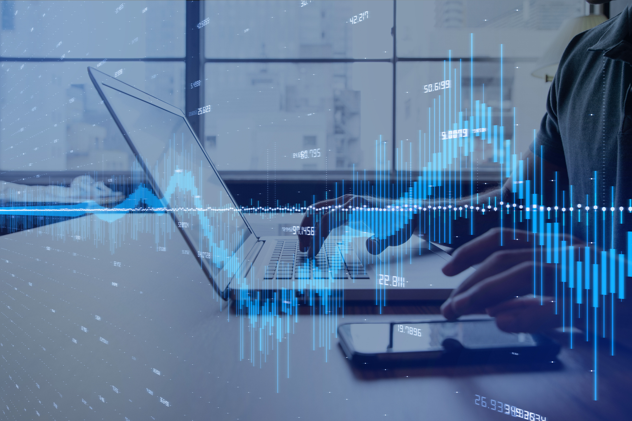 A person sitting in front of a computer with stock graph overlayed on top of the image.