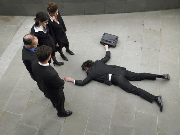 A business person that fell down on the sidewalk.