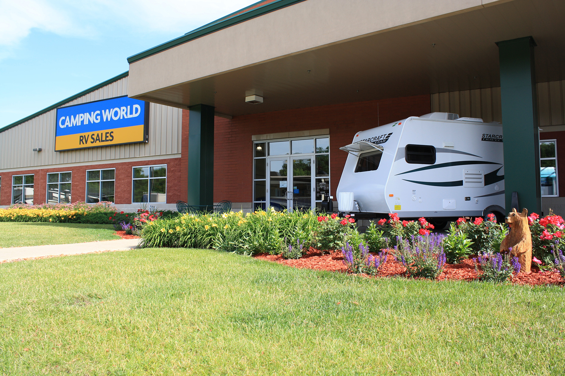 Camping World RV sales sign on a large building with an RV out front