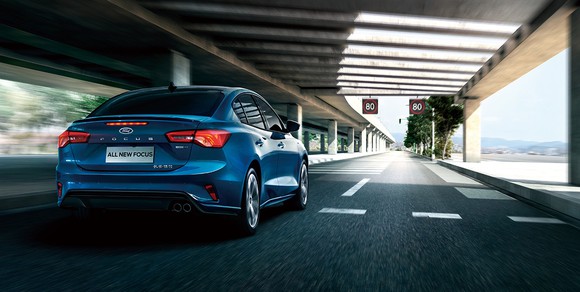 A blue 2019 Ford Focus sedan, seen from behind on a Chinese city street. 