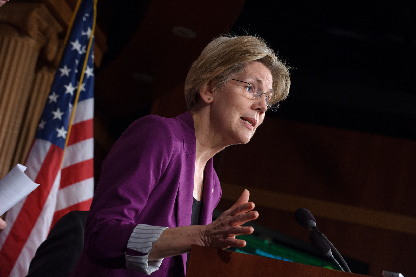 Massachusetts Sen. Elizabeth Warren speaking to reporters from behind a podium.