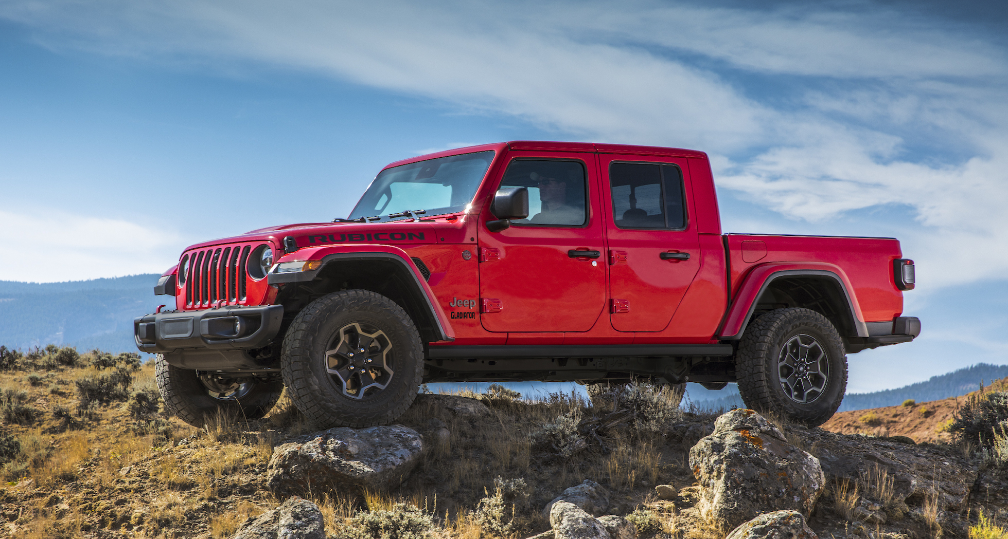 A red Jeep Gladiator, a pickup truck based on the Jeep Wrangler Unlimited off-road SUV.