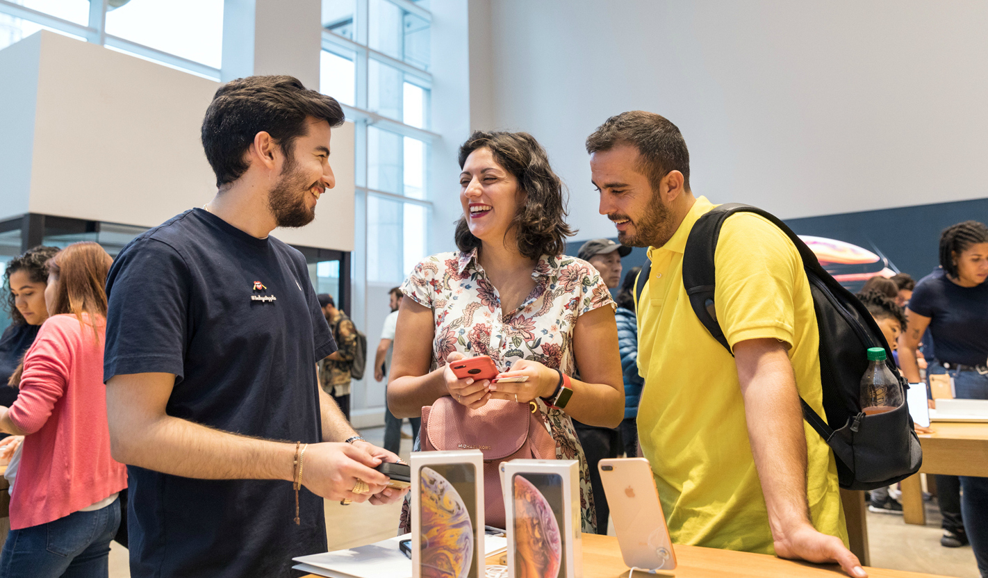 Customers look at iPhones in an Apple store.