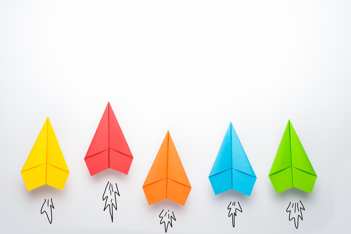 Paper kites of different colors racing higher.