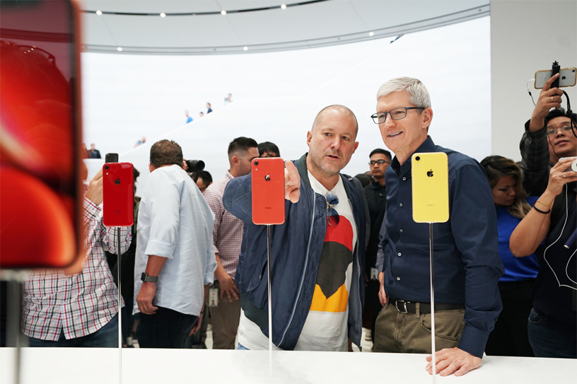 Apple CEO Tim Cook, right, and Chief Design Officer Jonny Ive, left, check out iPhones in an Apple store.