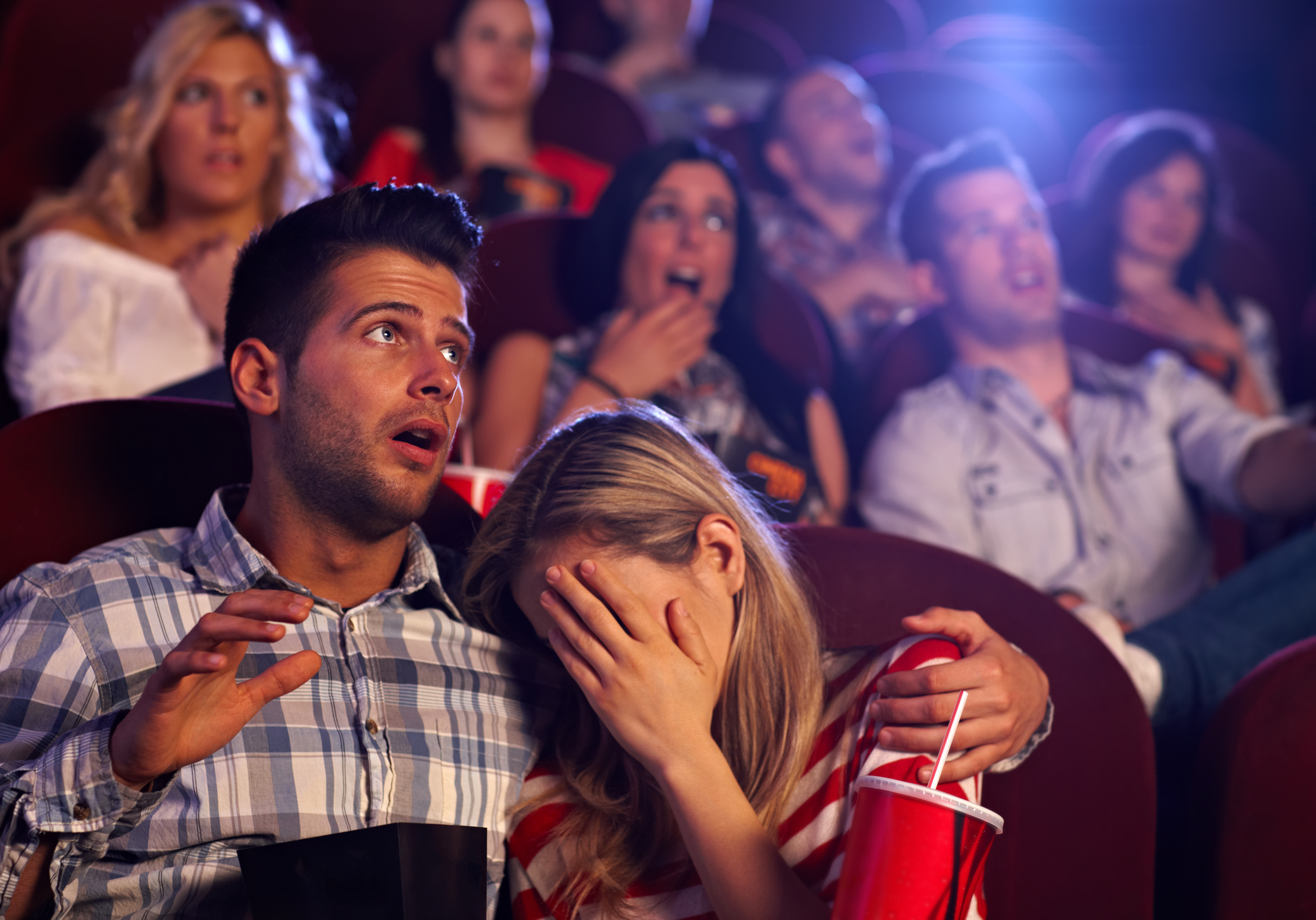 Moviegoers reacting to a horror film.