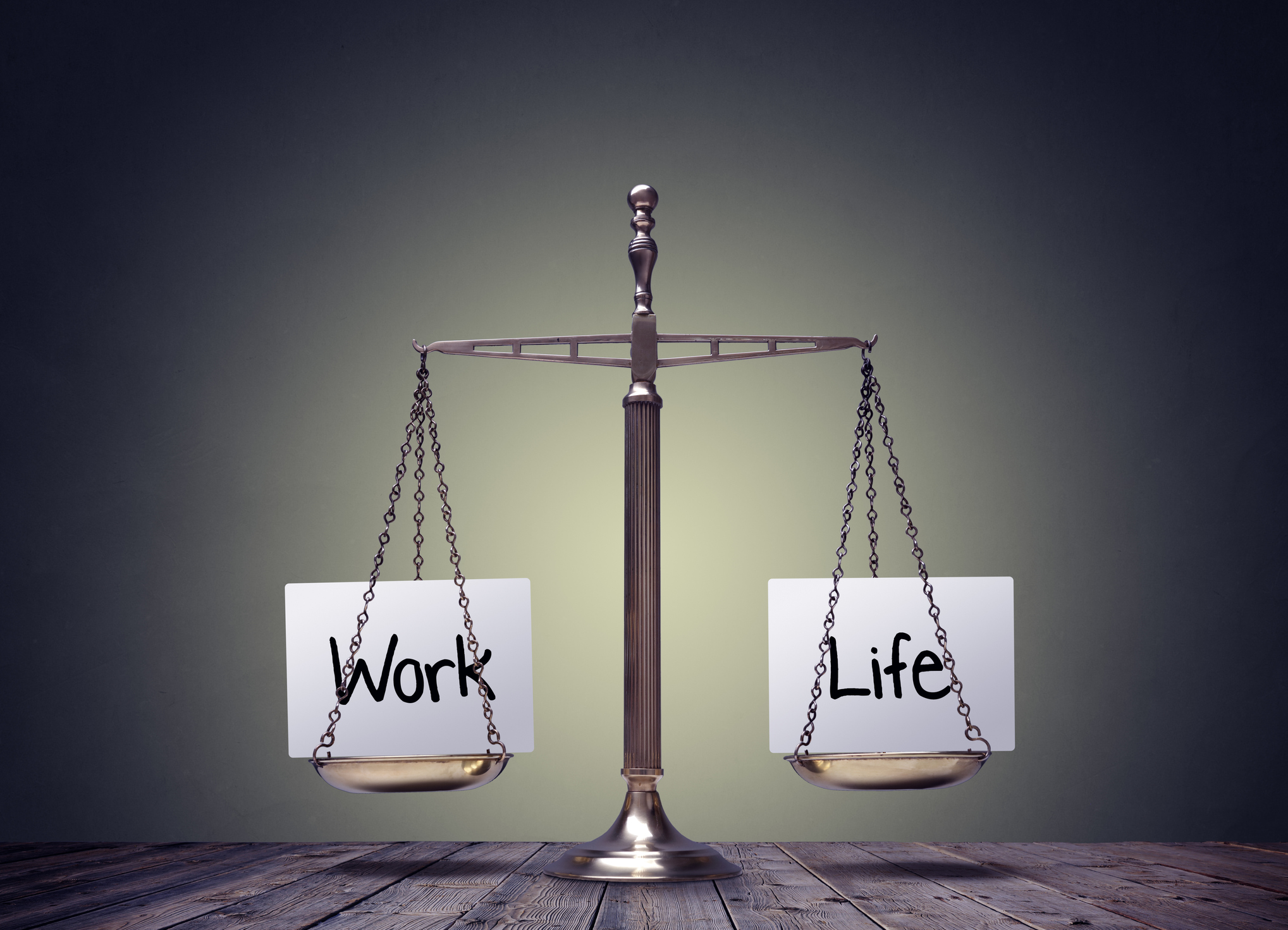 A balance scale carries the words work and life.