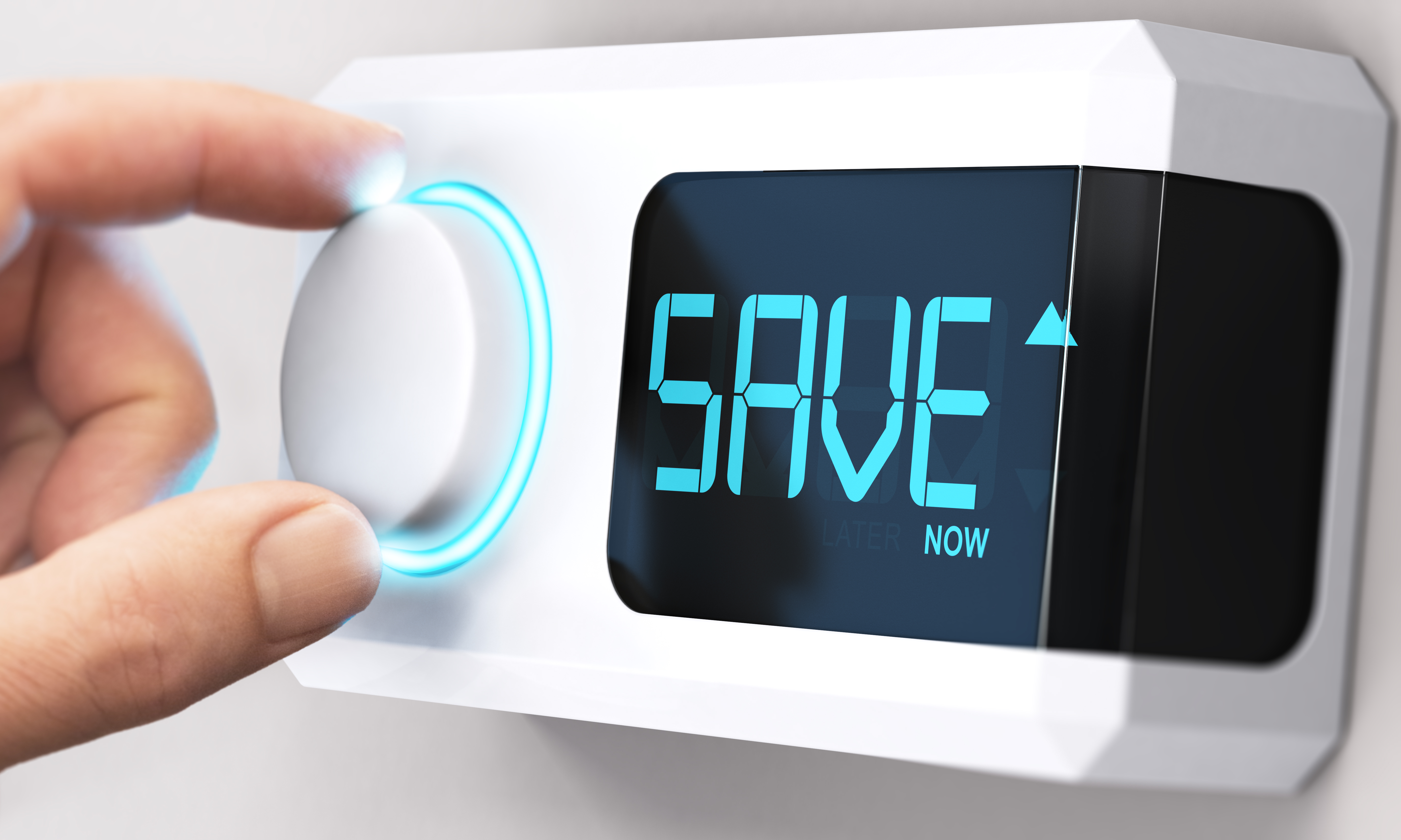 A hand turning a thermostat dial to SAVE NOW.