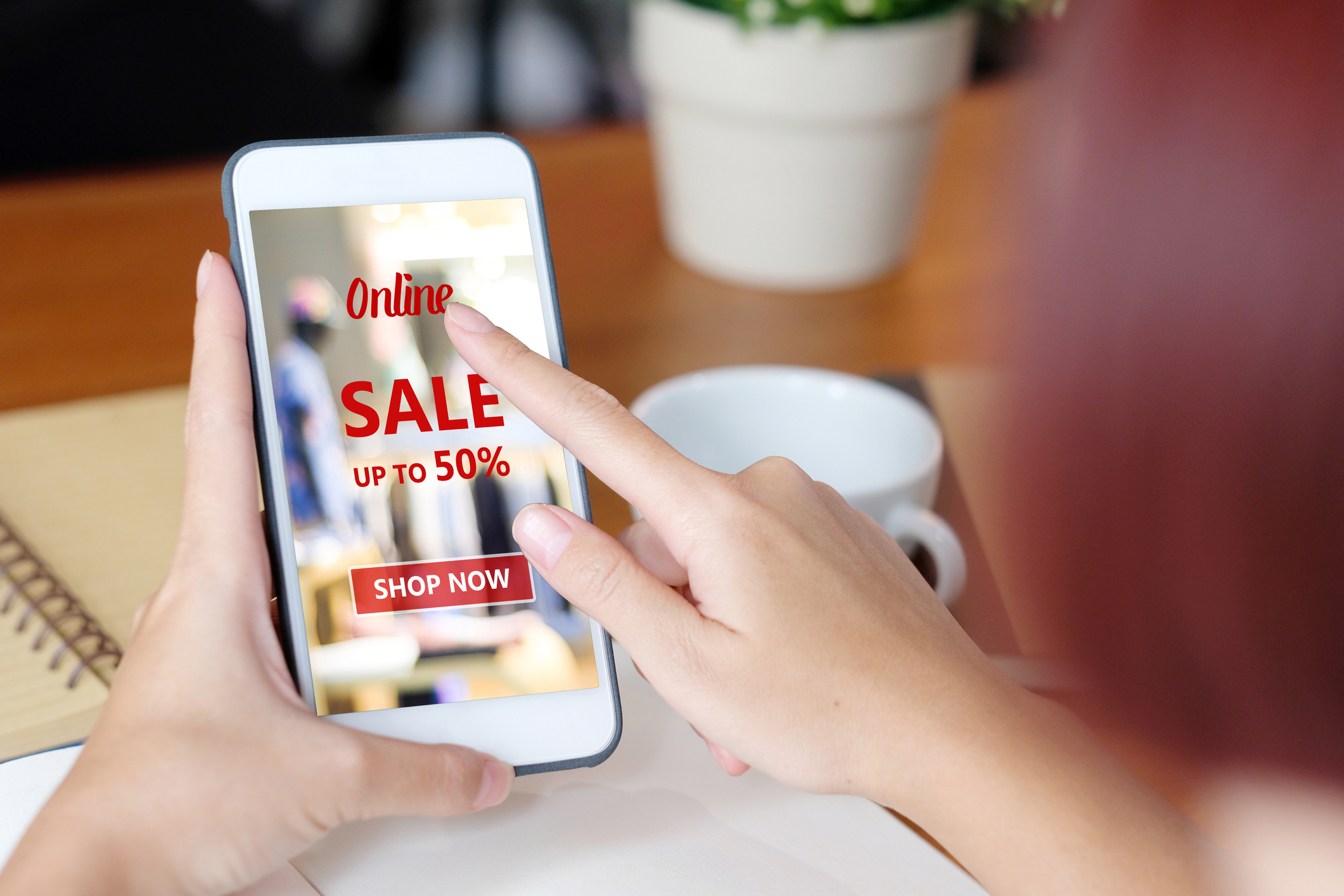 Woman on phone looking at digital coupon advertising.
