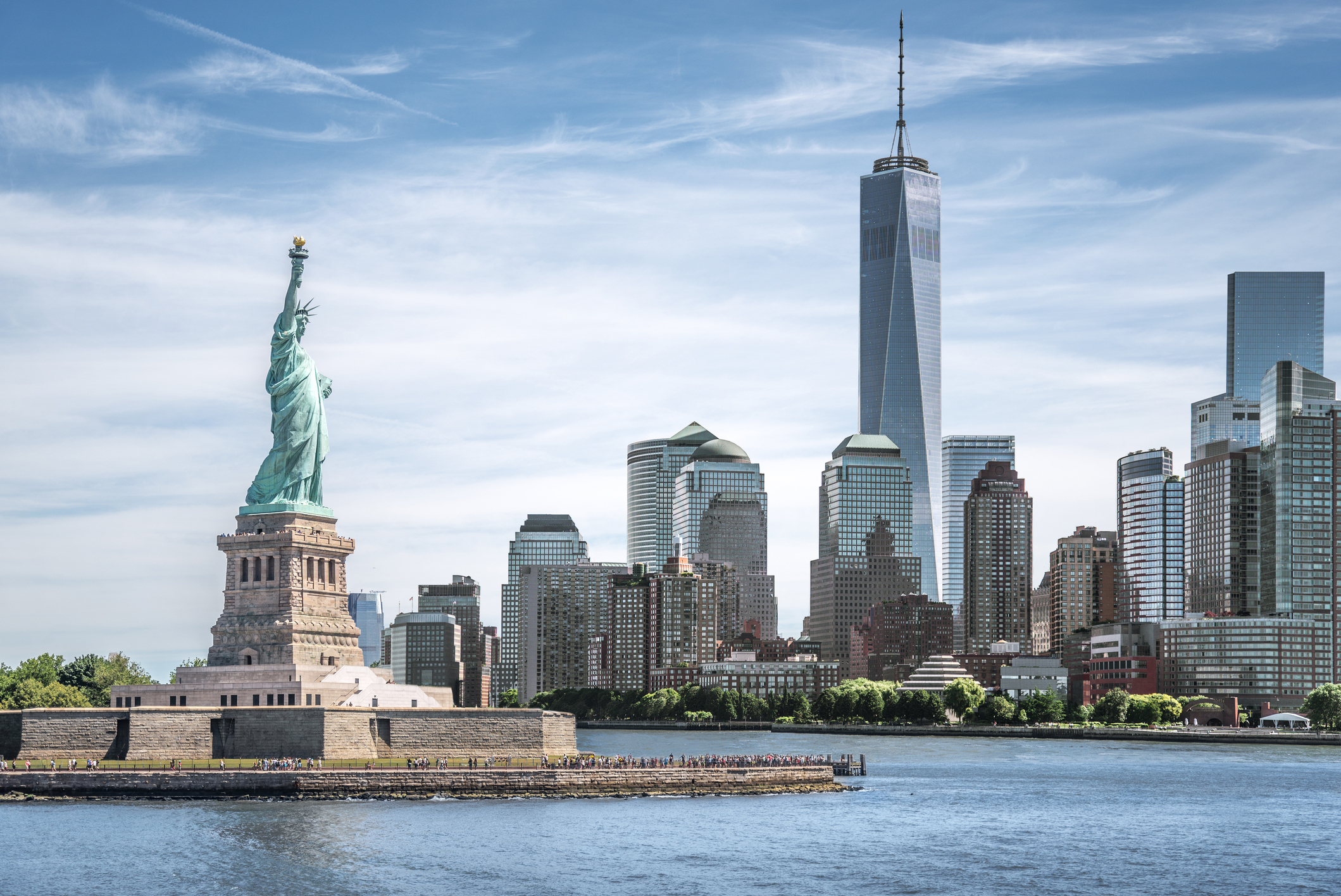 A view of New York City's Manhattan landscape, with the Statue of Liberty in the foreground.