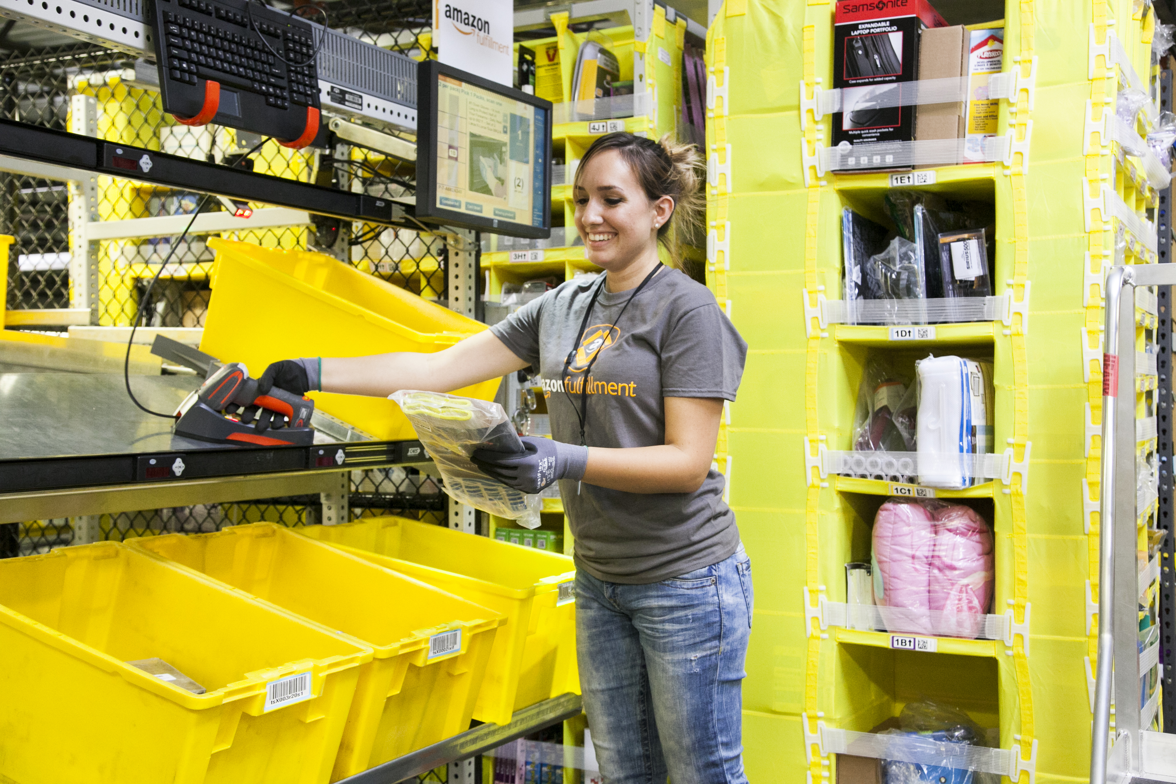 A smiling Amazon employee in a warehouse