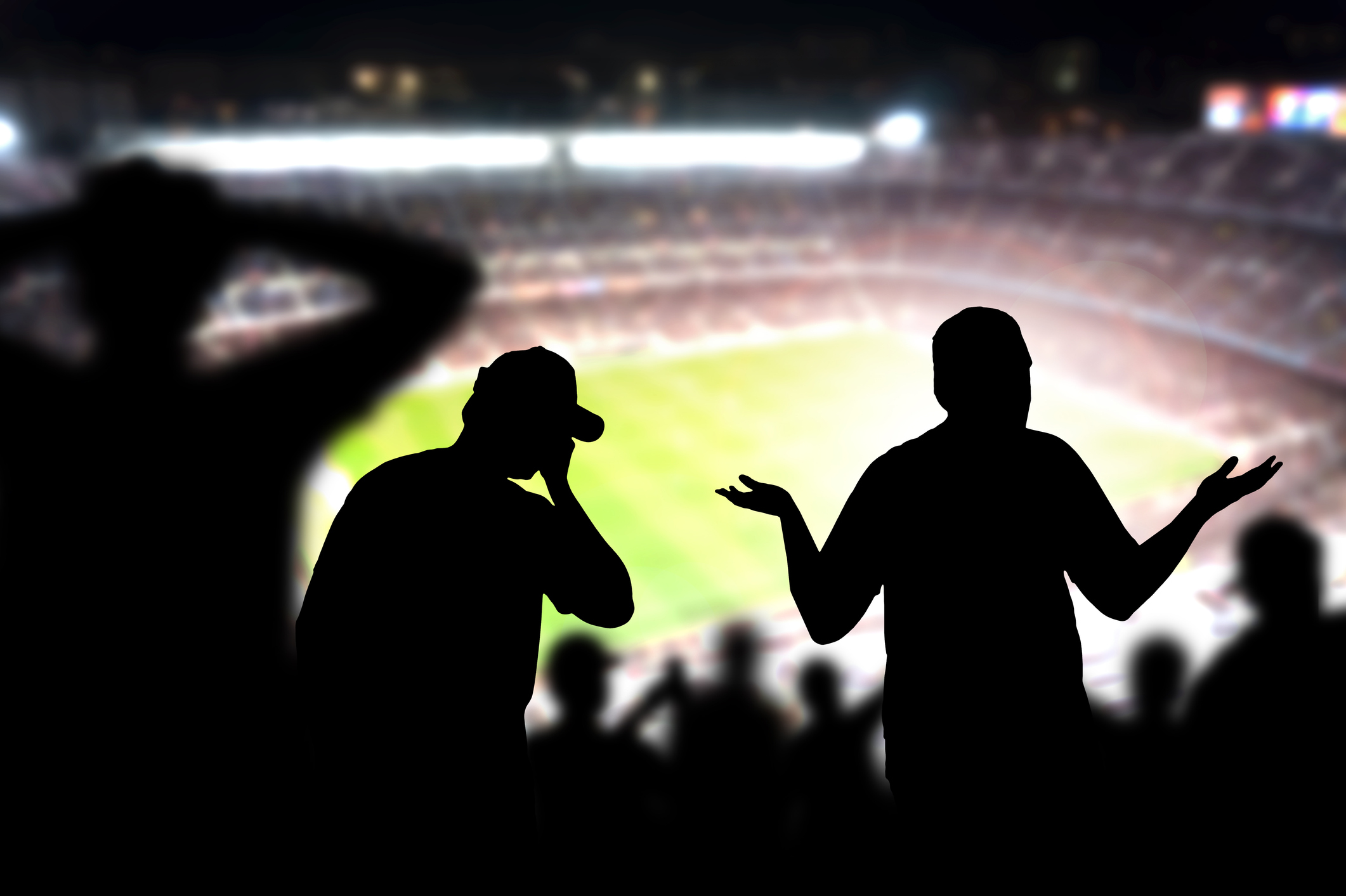 People in silhouette in a sports stadium