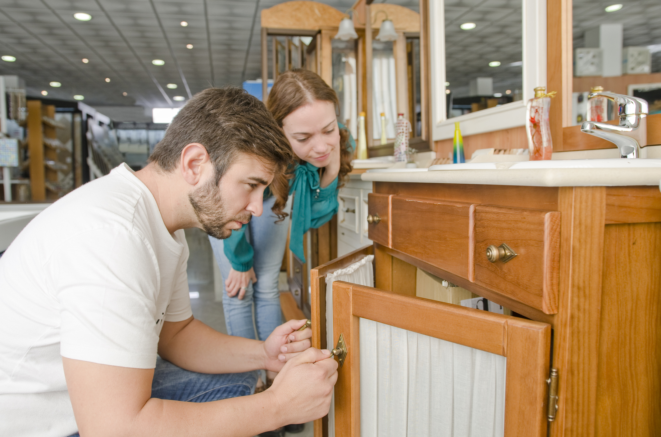 A man and a woman inspect a bathroom vanity in a home improvement store